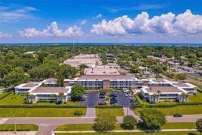An aerial view of a multi-story apartment complex surrounded by trees and a parking lot — 6100 12TH STREET S UNIT 315, ST PETERSBURG, FL