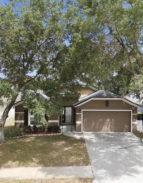 A single-story house with a tan stucco exterior, a two-car garage, and a front entrance — 553 MAIDENHAIR COURT, ORANGE CITY, FL