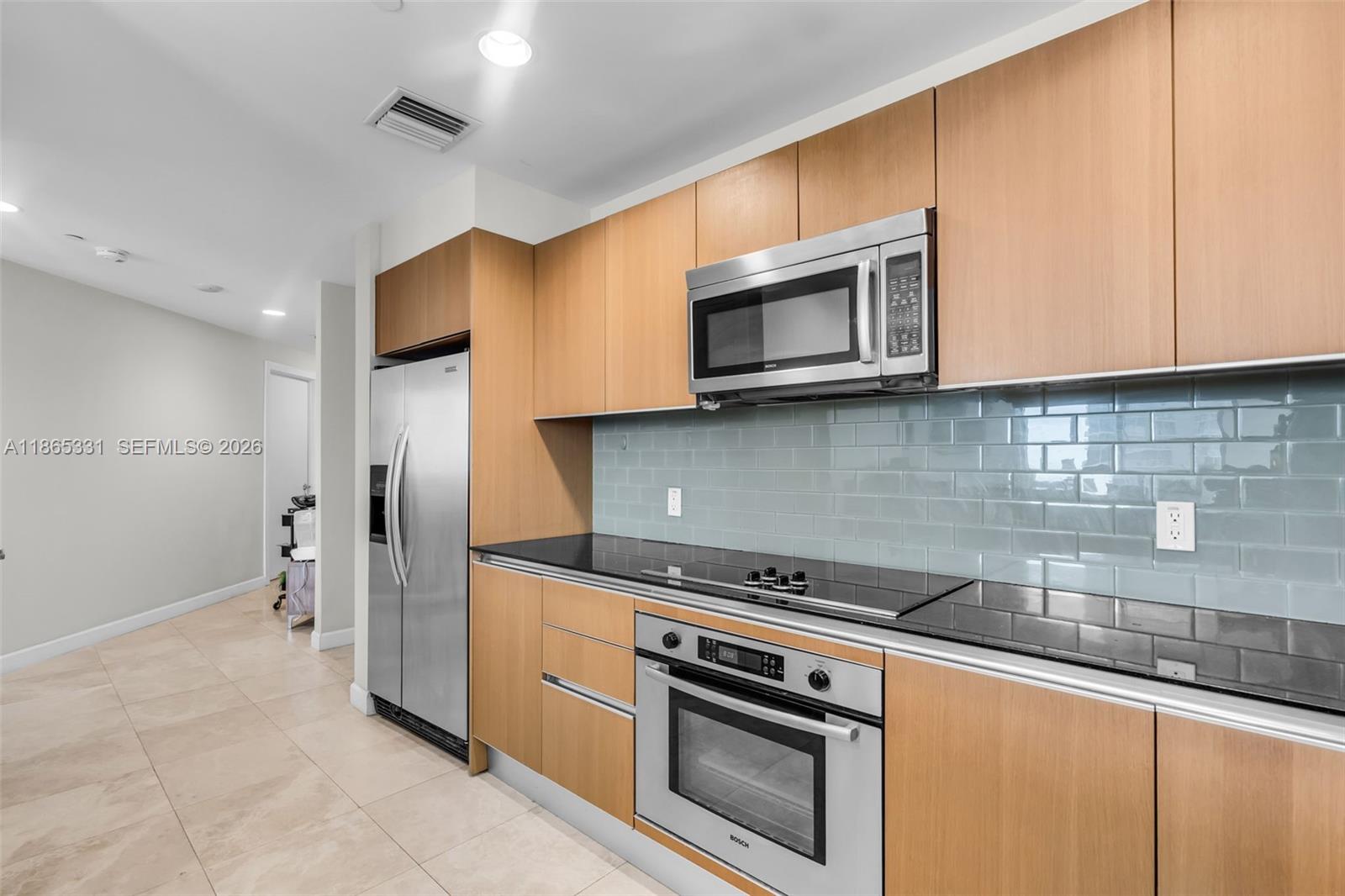 A walk-in closet features white shelving, drawers, hanging clothes, and wood-look flooring — 1060 Brickell Ave # 3601, Miami FL 33131, MIAMI, FL