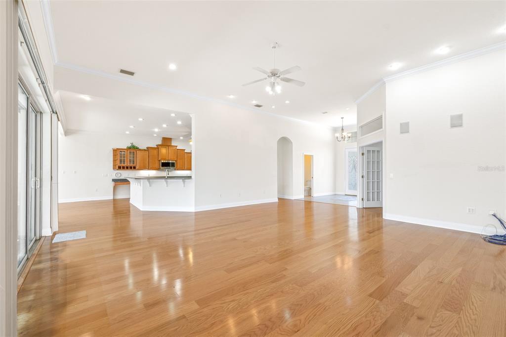 An open-concept living area features hardwood floors, a kitchen with wood cabinets, and recessed lighting — 6779 HUNTINGTON HILLS BOULEVARD, LAKELAND, FL