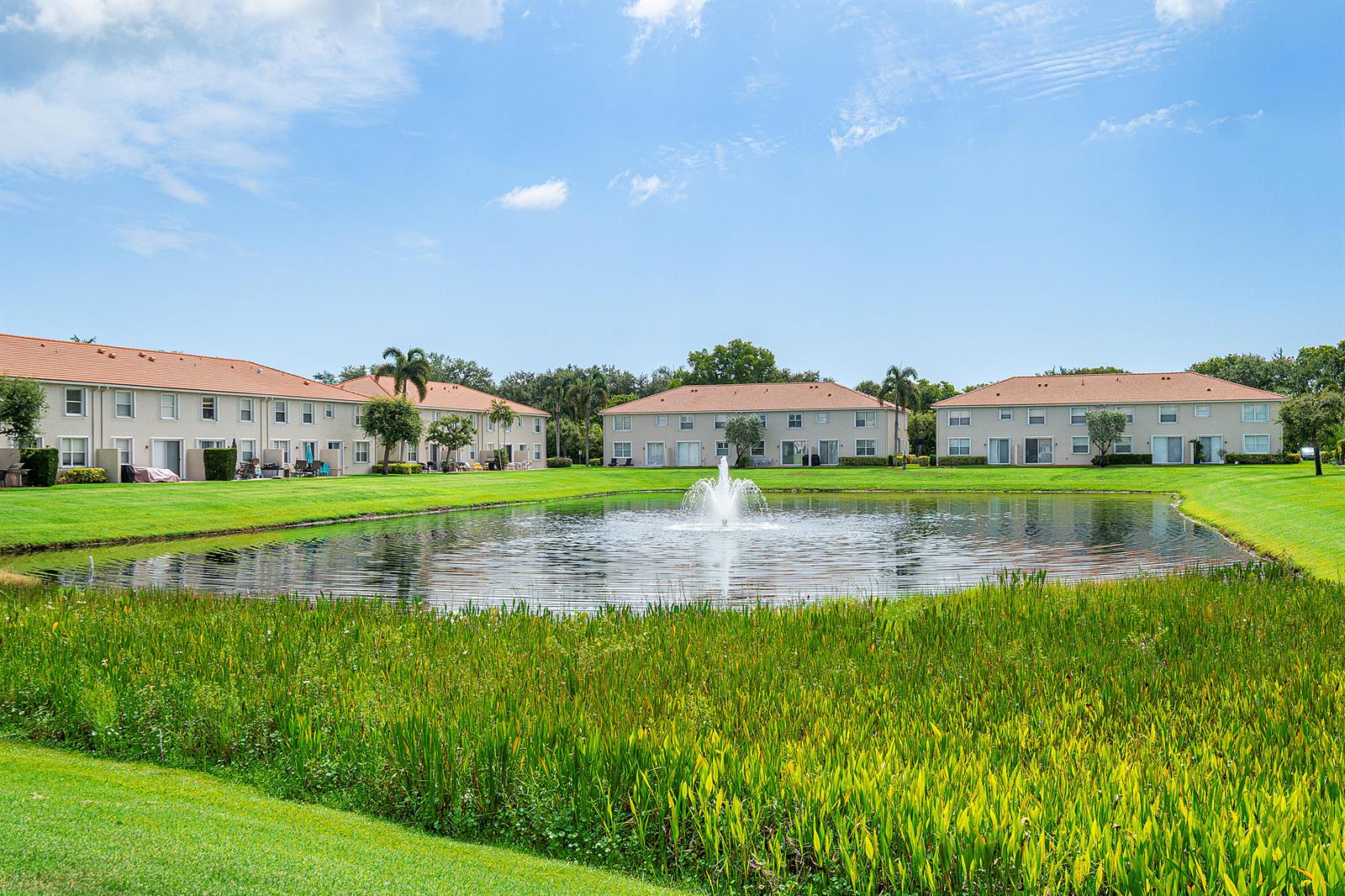 A pond with a fountain sits in front of several two-story apartment buildings — 16122 Poppy Seed Circle Unit 1401, Delray Beach FL 33484, DELRAY BEACH, FL