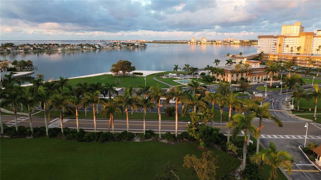 An aerial view of a waterfront property featuring palm trees, a parking lot, and buildings — 4900 BRITTANY DRIVE S UNIT 1003, ST PETERSBURG, FL