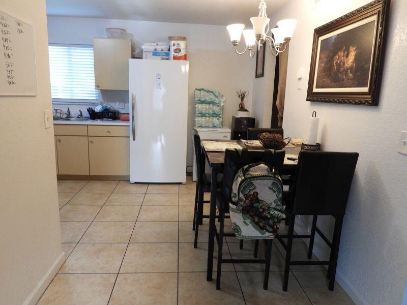 A kitchen and dining area features tile flooring, a white refrigerator, and a dark dining set — 2764 NW 1st Court, Pompano Beach FL 33069, POMPANO BEACH, FL