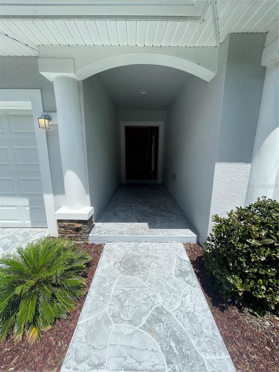 A concrete walkway leads to the covered entryway of a house with a white pillar — 232 CLAYTON STREET, BRANDON, FL