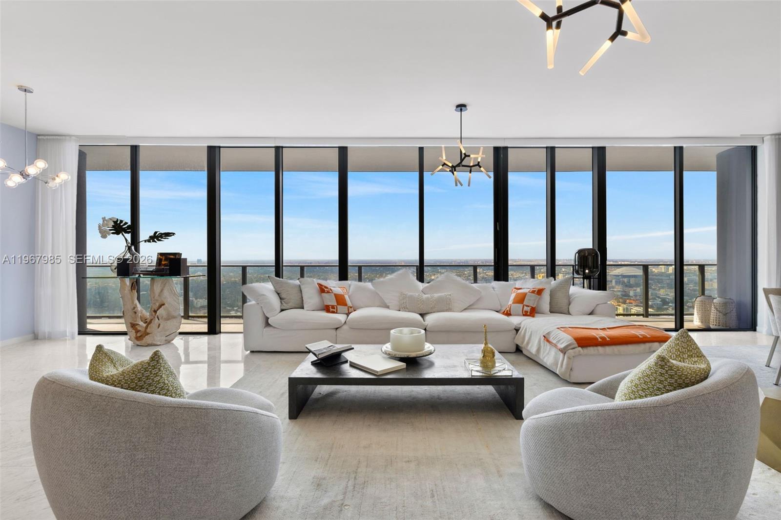 A modern living room features a white sectional sofa, two armchairs, and floor-to-ceiling windows — 1000 Brickell Plz, Miami FL 33131, MIAMI, FL