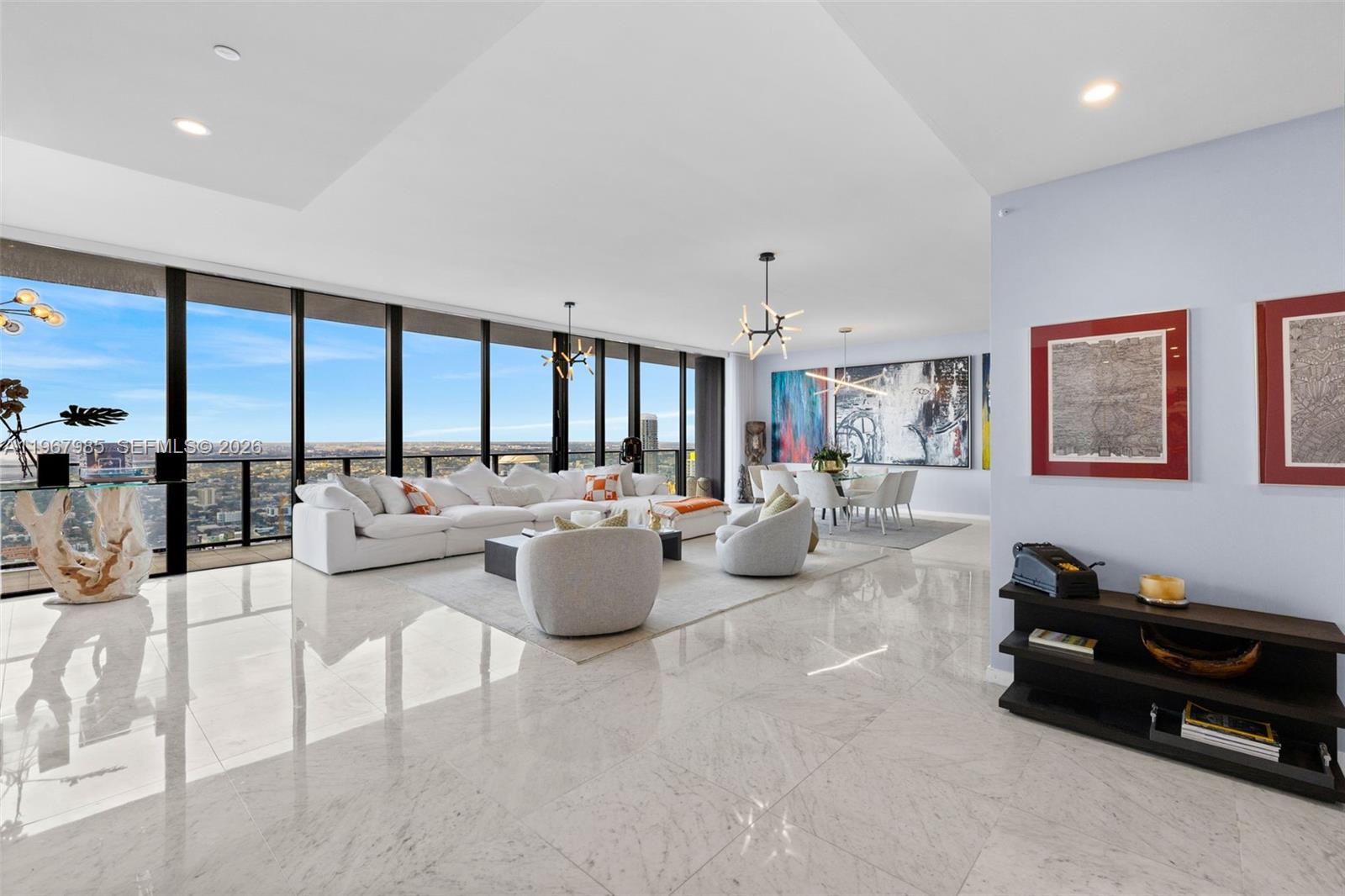 A spacious living and dining area features white marble floors, floor-to-ceiling windows, and modern decor — 1000 Brickell Plz, Miami FL 33131, MIAMI, FL