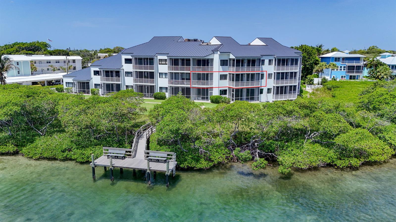 An aerial view of a multi-story apartment building with a wooden dock on the water — 200 Waterway Road # 206, Tequesta FL 33469, TEQUESTA, FL