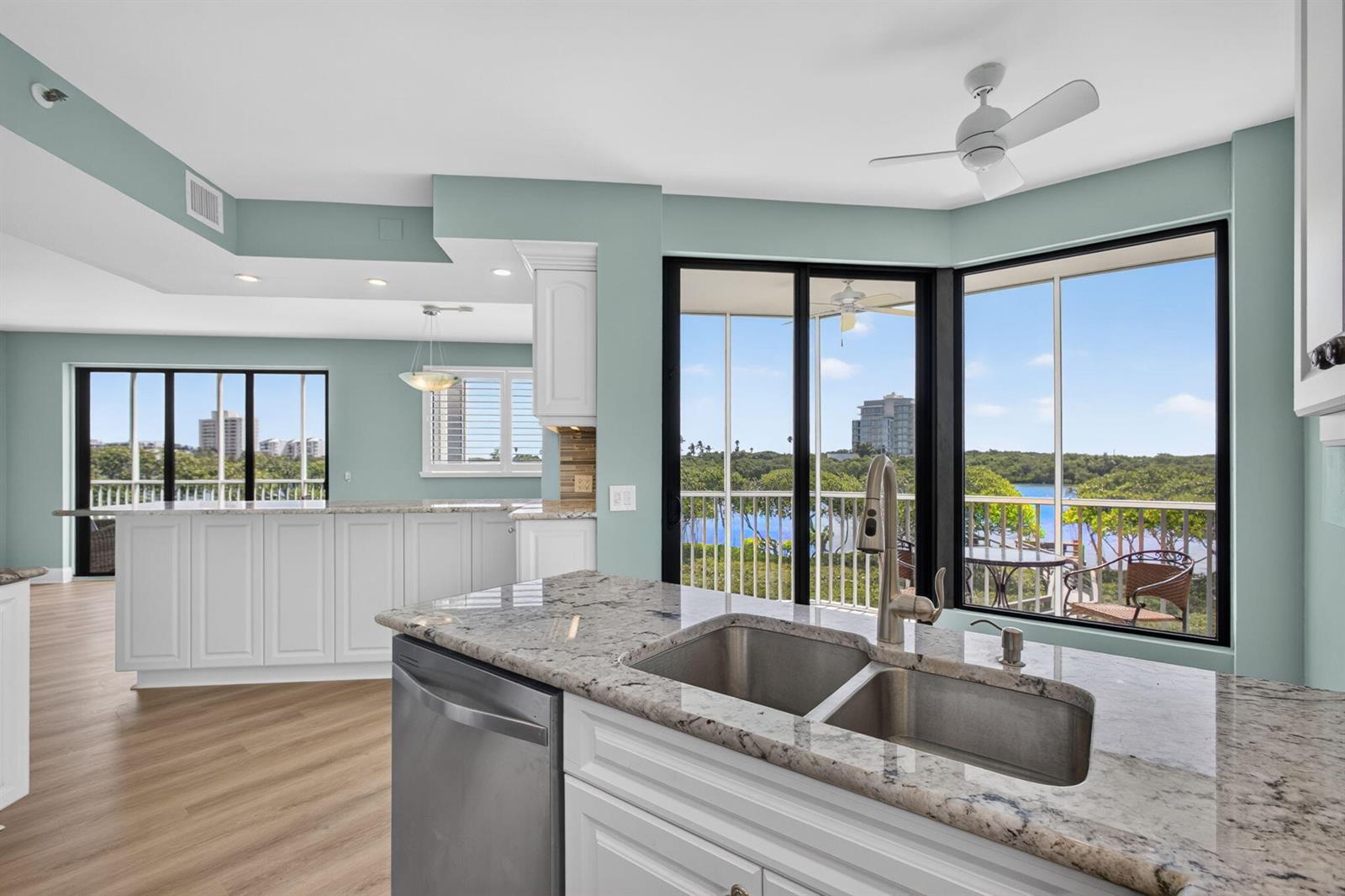 A kitchen with white cabinets, granite countertops, and a view of water and trees — 200 Waterway Road # 206, Tequesta FL 33469, TEQUESTA, FL