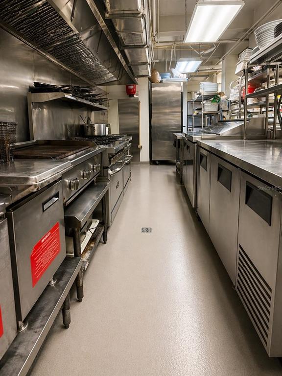 A commercial kitchen features stainless steel appliances, a ventilation hood, and a light-colored floor — 619 CALLE CERRA, SAN JUAN, PR