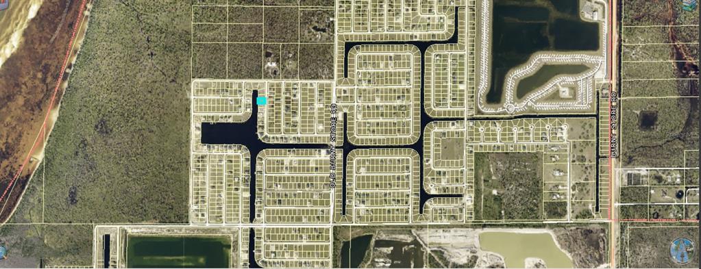 A vacant grassy lot sits next to a paved road under a clear blue sky — 4008 NW 42ND PLACE, CAPE CORAL, FL