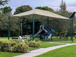 A playground with a large shade canopy sits in a grassy park area — 2424 Monroe Street, Hollywood FL 33020, HOLLYWOOD, FL