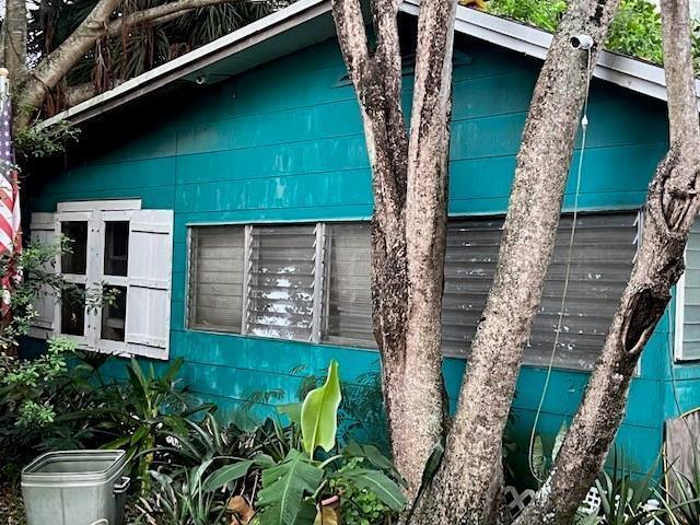 A teal-sided house exterior features white-shuttered windows and a security camera mounted on a tree — 2424 Monroe Street, Hollywood FL 33020, HOLLYWOOD, FL