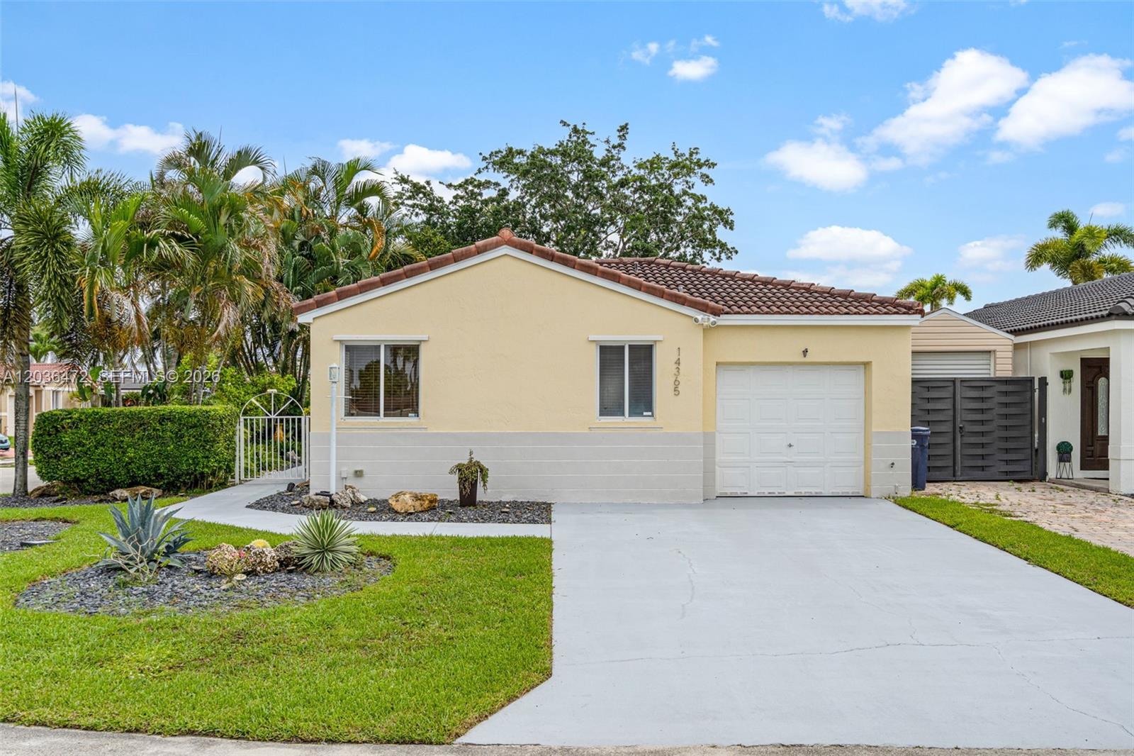 A single-story yellow house with a tile roof, a garage, and a front yard — 14365 SW 175th Ter, Miami FL 33177, MIAMI, FL