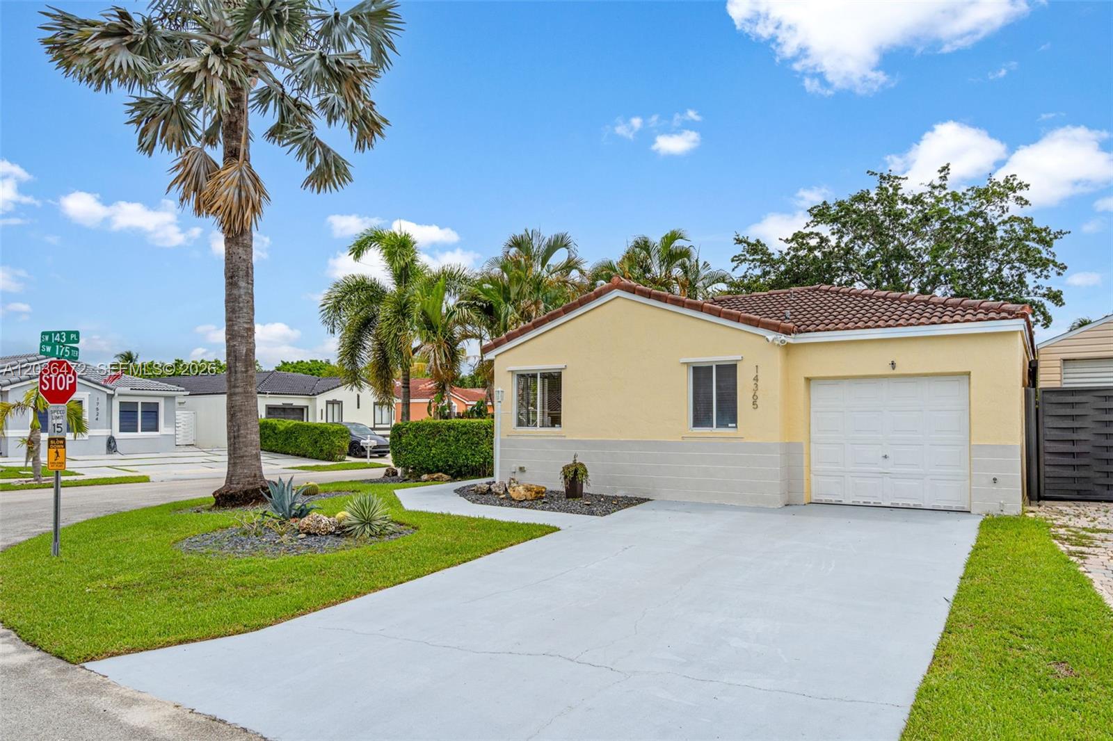 A yellow single-story house with a white garage door and a concrete driveway — 14365 SW 175th Ter, Miami FL 33177, MIAMI, FL