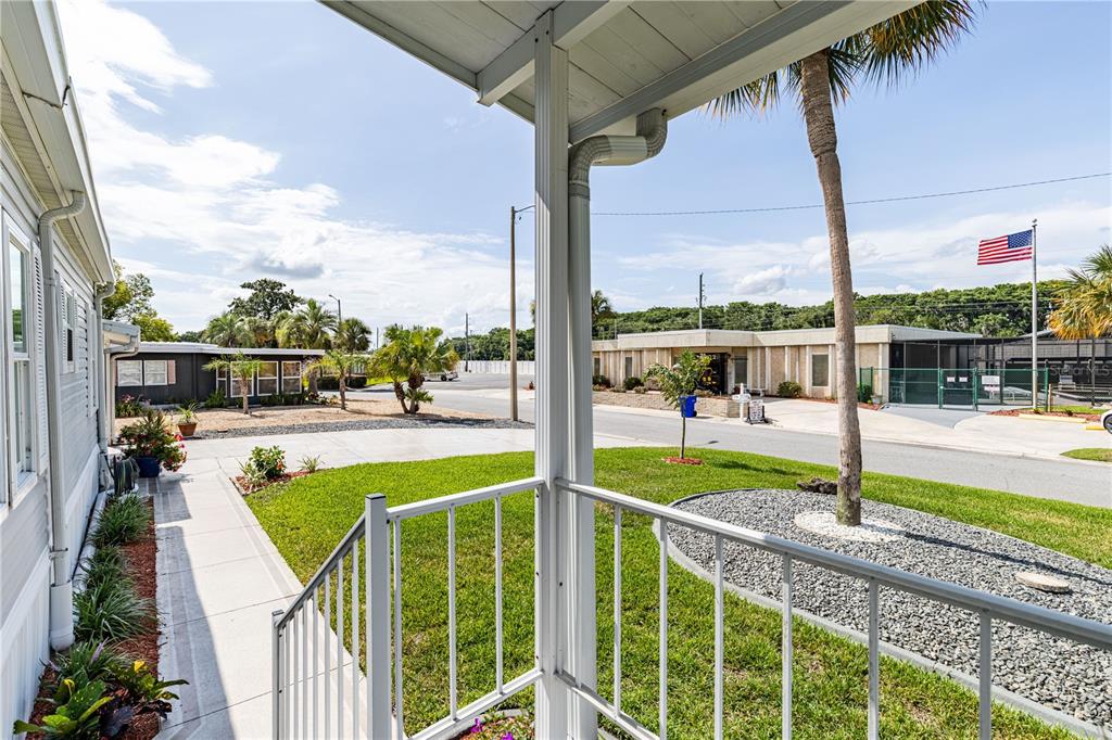 A view from a covered porch looking out at a residential street with palm trees — 2611 VINDALE ROAD, TAVARES, FL