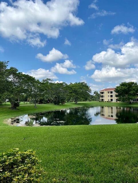 A pond sits in front of a multi-story apartment building surrounded by green lawns — 7472 La Paz Boulevard # 103, Boca Raton FL 33433, BOCA RATON, FL