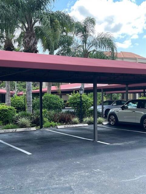 A covered parking area features numbered spaces and a white car parked underneath — 7472 La Paz Boulevard # 103, Boca Raton FL 33433, BOCA RATON, FL