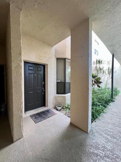 A dark front door is set into a stucco entryway with a small window nearby — 7472 La Paz Boulevard # 103, Boca Raton FL 33433, BOCA RATON, FL