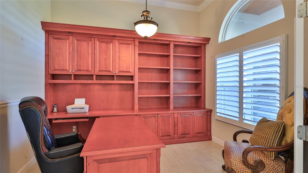 A home office features a large wooden desk, built-in shelving, and a leather executive chair — 2904 PALMA LANE, NEW SMYRNA BEACH, FL