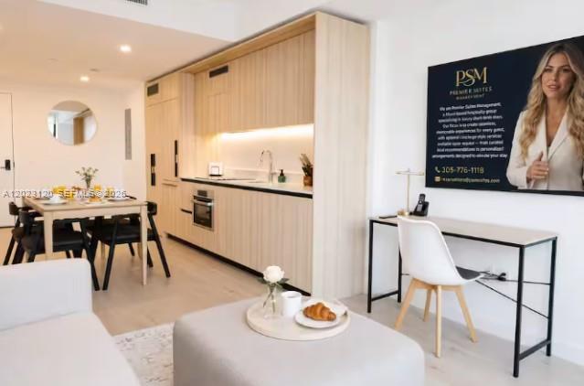 A modern studio apartment features a light wood kitchen, dining area, and a workspace — 225 N Miami Ave # 3204, Miami FL 33128, MIAMI, FL