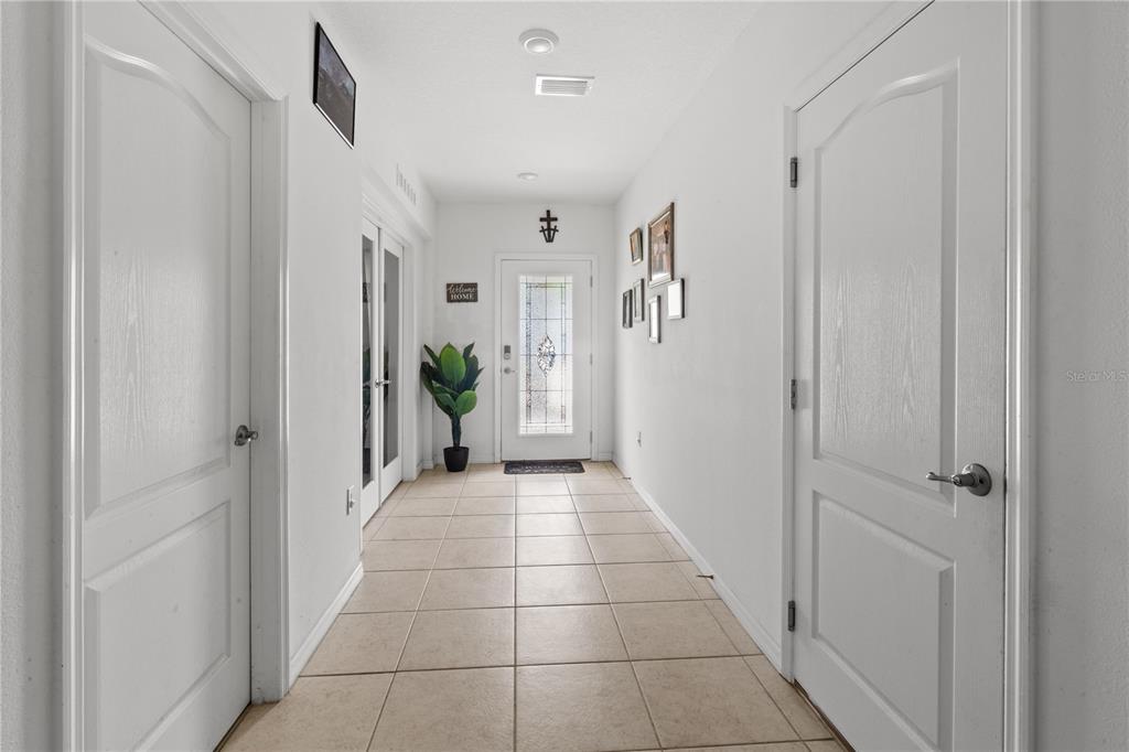 A tiled entryway features white walls, two interior doors, and a glass-paneled front door — 672 NW 247TH TERR, NEWBERRY, FL