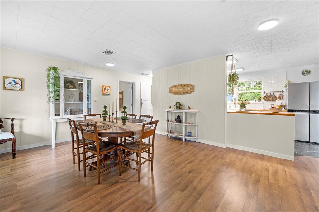 A dining area with a wooden table and chairs sits adjacent to an open kitchen — 23439 CROOM ROAD, BROOKSVILLE, FL