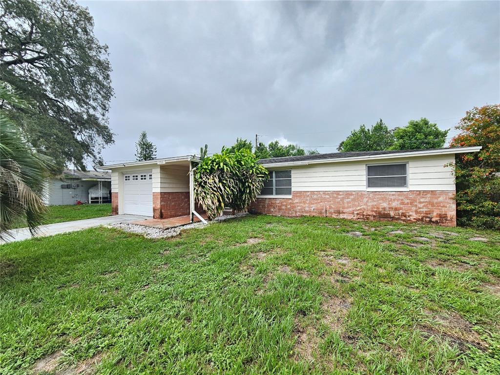 A single-story house with a brick and white siding exterior and a front-facing garage — 1702 AQUA LANE, HOLIDAY, FL