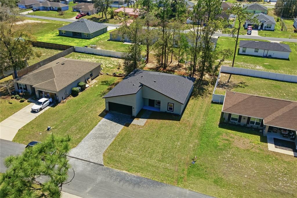 An aerial view shows a modern single-story house with a dark roof and driveway — 12797 SW 58TH CIRCLE, OCALA, FL