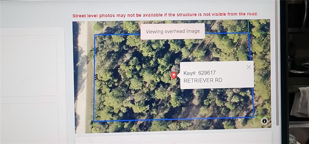 An overhead satellite map shows a rectangular, wooded plot of land bordering a road — 18164 RETRIEVER ROAD, WEEKI WACHEE, FL