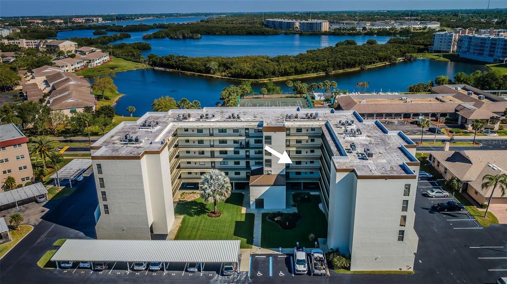 An aerial view of a multi-story apartment building with a central courtyard and parking lot — 9860 62ND TERRACE N UNIT 1025, ST PETERSBURG, FL