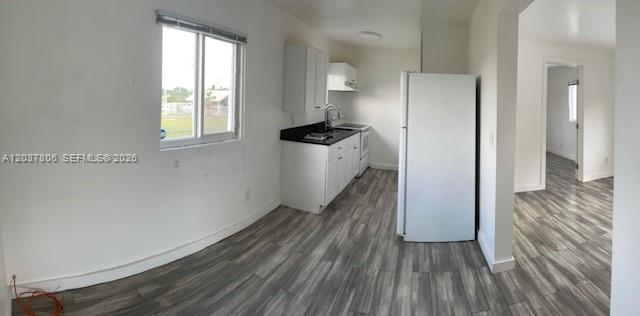 A kitchen with white cabinets, a white refrigerator, and gray wood-look flooring — 337 NW 59th Ter # A, Miami FL 33127, MIAMI, FL