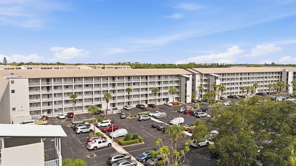 An aerial view shows a large multi-story apartment building with a parking lot below — 3446 LAKE BAYSHORE DRIVE UNIT 416, BRADENTON, FL