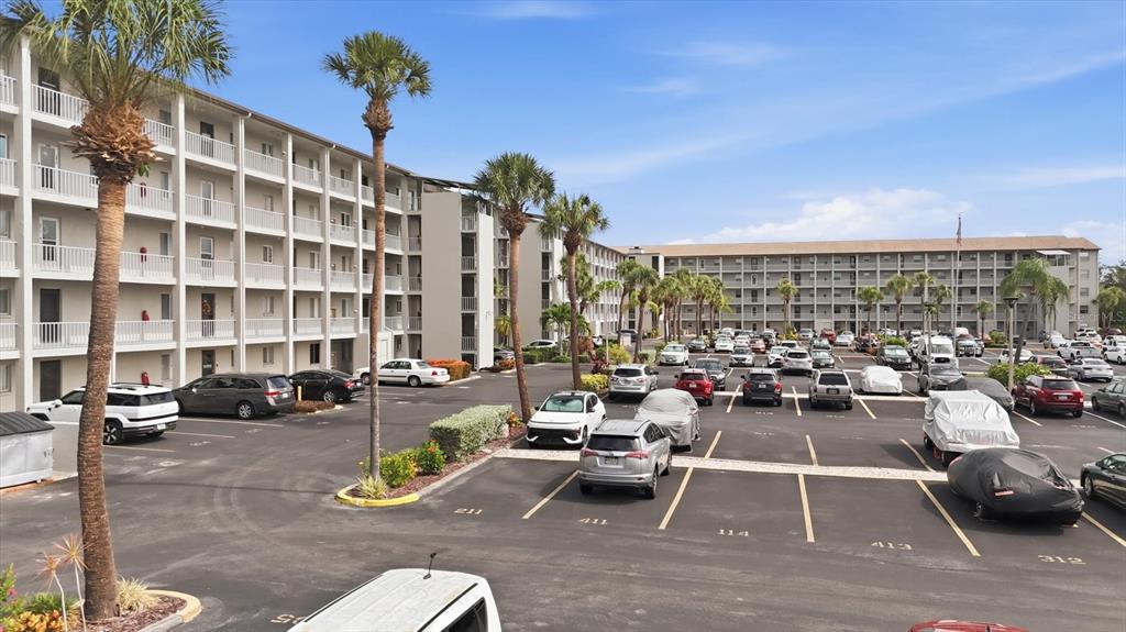 A large apartment complex features a parking lot with many cars and palm trees — 3446 LAKE BAYSHORE DRIVE UNIT 416, BRADENTON, FL