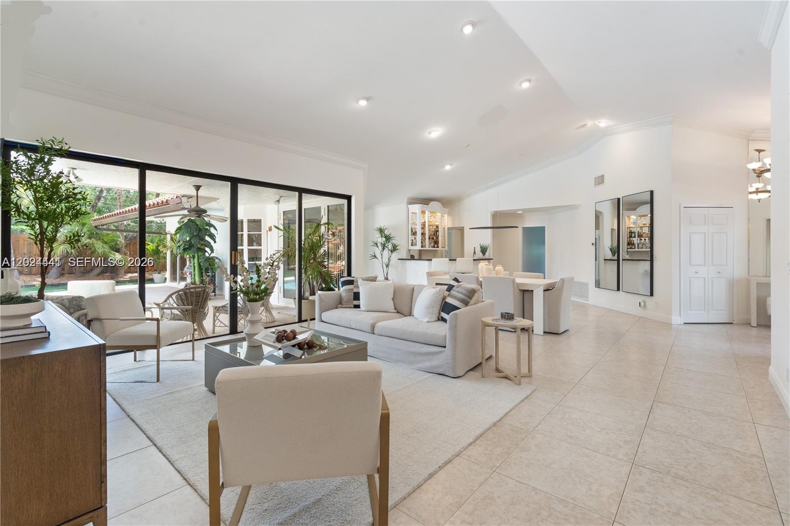 A bright living room features a sofa, armchairs, dining area, and large sliding glass doors — 2900 NW 25th Way, Boca Raton FL 33434, BOCA RATON, FL