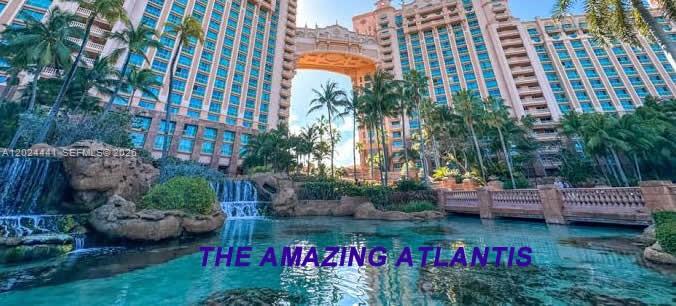 A view of the Atlantis resort exterior featuring a large lagoon, waterfalls, and palm trees — 2900 NW 25th Way, Boca Raton FL 33434, BOCA RATON, FL
