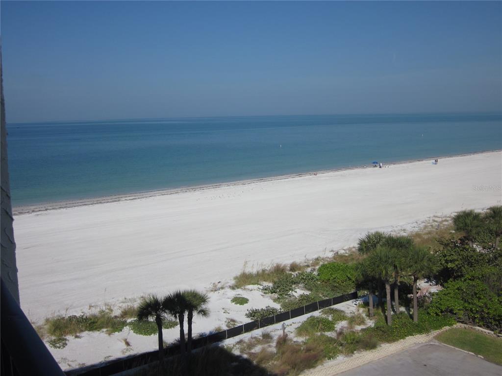 A high-angle view of a white sand beach and the ocean from a balcony — 1400 GULF BOULEVARD UNIT 608, CLEARWATER BEACH, FL