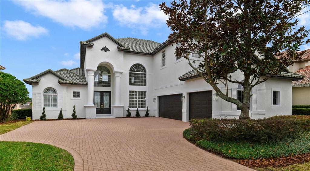 A two-story white stucco house with a tiled roof and a paved driveway — 408 CHELSEA AVENUE, DAVENPORT, FL
