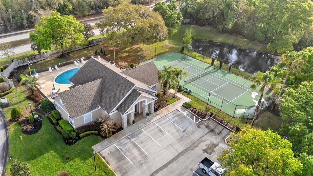 An aerial view shows a community clubhouse with a pool, tennis courts, and parking lot — 6540 LAKE CLARK DRIVE, LAKELAND, FL