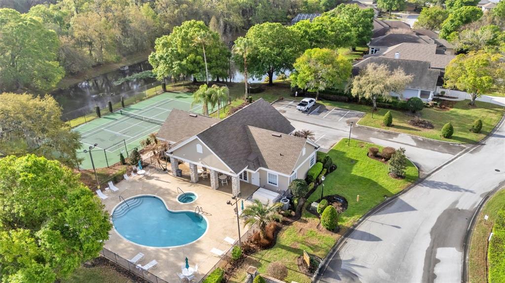 An aerial view shows a community clubhouse with a swimming pool and tennis courts — 6540 LAKE CLARK DRIVE, LAKELAND, FL