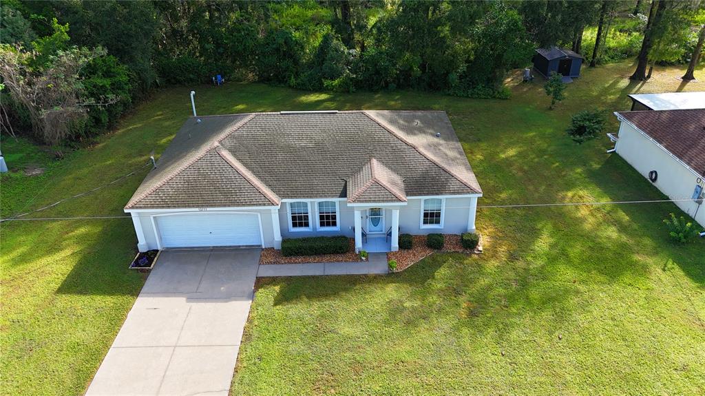An aerial view of a single-story house with a shingled roof and a concrete driveway — 13777 SE 44TH AVENUE, SUMMERFIELD, FL