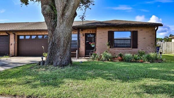 A single-story brick house with a garage and a large tree in the front yard — 418 FALCON AVENUE, EDGEWATER, FL