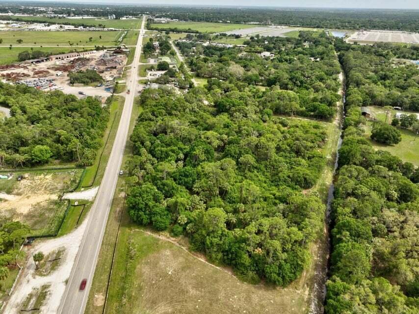 An aerial view shows a wooded lot bordering a road and a narrow drainage canal — 2357 NW 32 Drive, Okeechobee FL 34972, OKEECHOBEE, FL