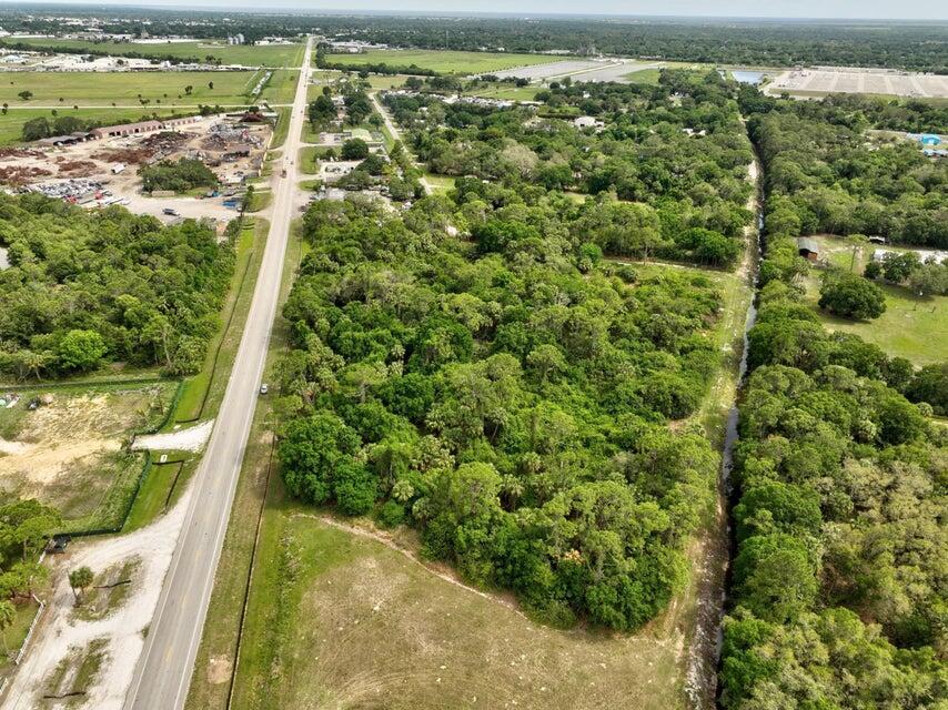 An aerial view shows a wooded lot bordered by a road and a drainage canal — 2357 NW 32 Drive, Okeechobee FL 34972, OKEECHOBEE, FL