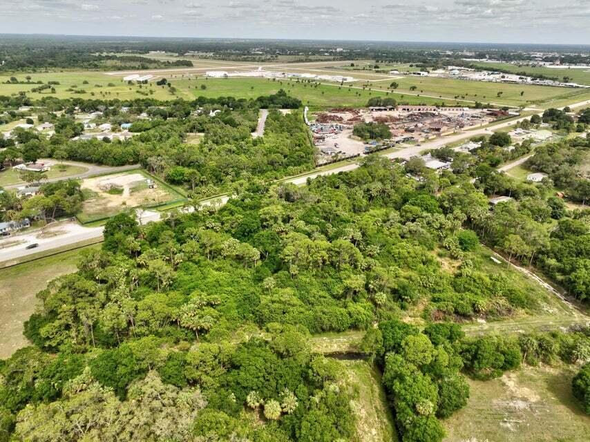 An aerial view shows a large, wooded lot adjacent to a road and industrial area — 2357 NW 32 Drive, Okeechobee FL 34972, OKEECHOBEE, FL