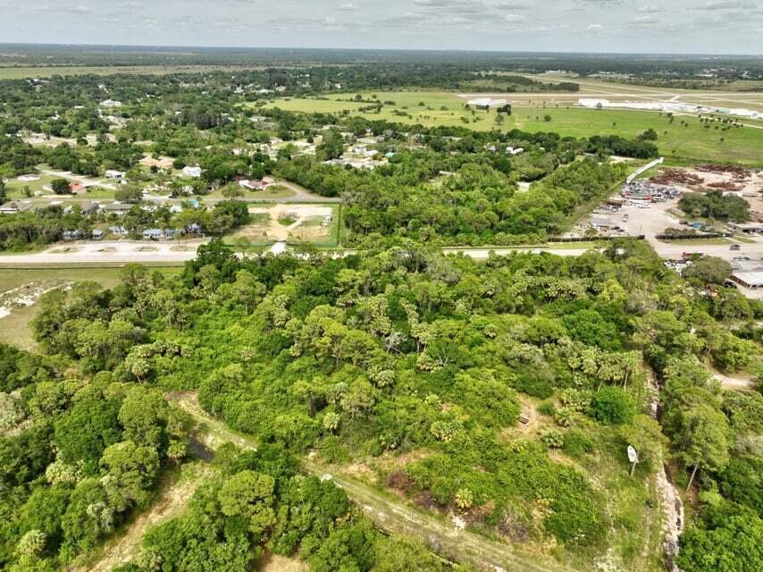 An aerial view shows a large, wooded lot adjacent to a road and residential area — 2357 NW 32 Drive, Okeechobee FL 34972, OKEECHOBEE, FL