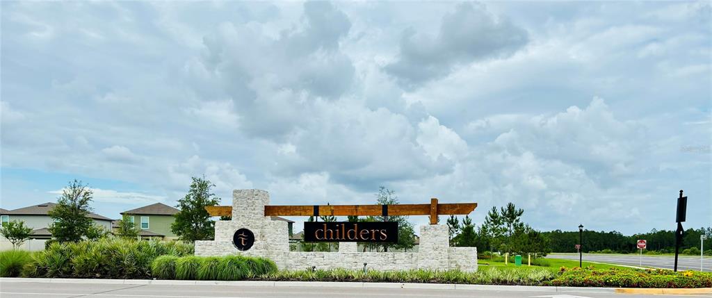 A stone monument sign with a wooden beam displays the name Childers near a road — 2141 LANIER ROAD, ZEPHYRHILLS, FL