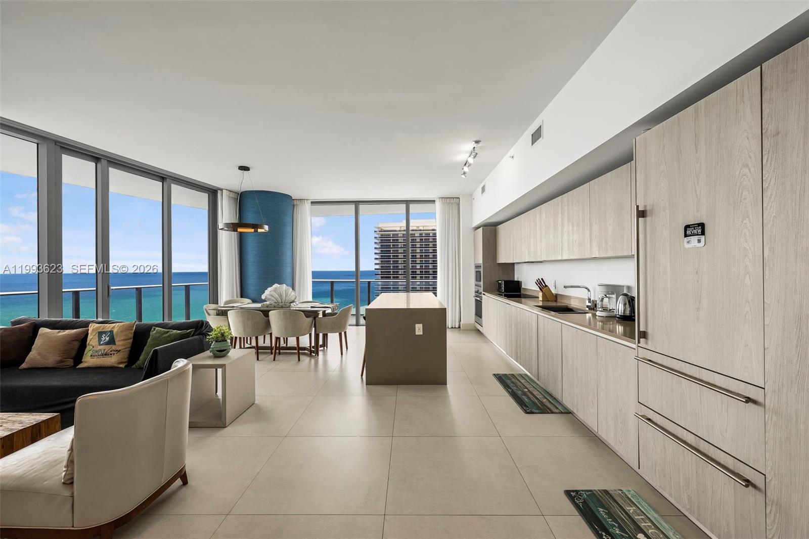 A modern open-concept kitchen and living area features light wood cabinetry and ocean views — 4111 S Ocean Dr, Hollywood FL 33019, HOLLYWOOD, FL