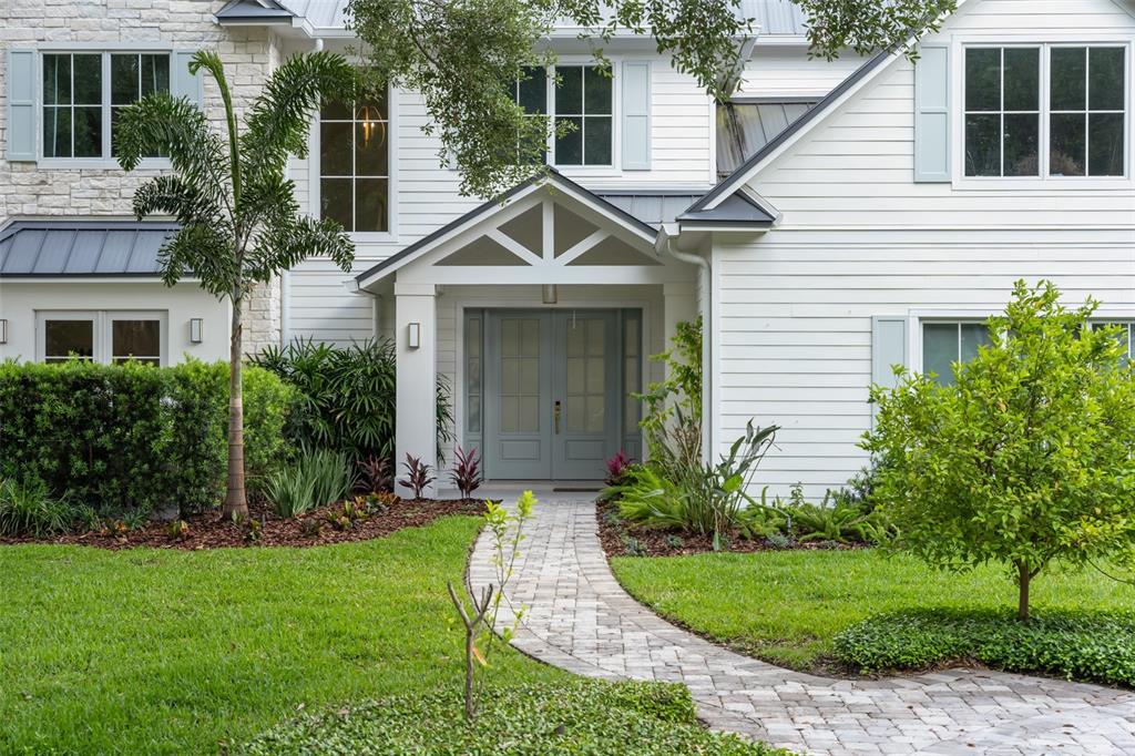 A white house with a stone facade, gray shutters, and a stone walkway to the entrance — 13542 SUNSET LAKES CIRCLE, WINTER GARDEN, FL