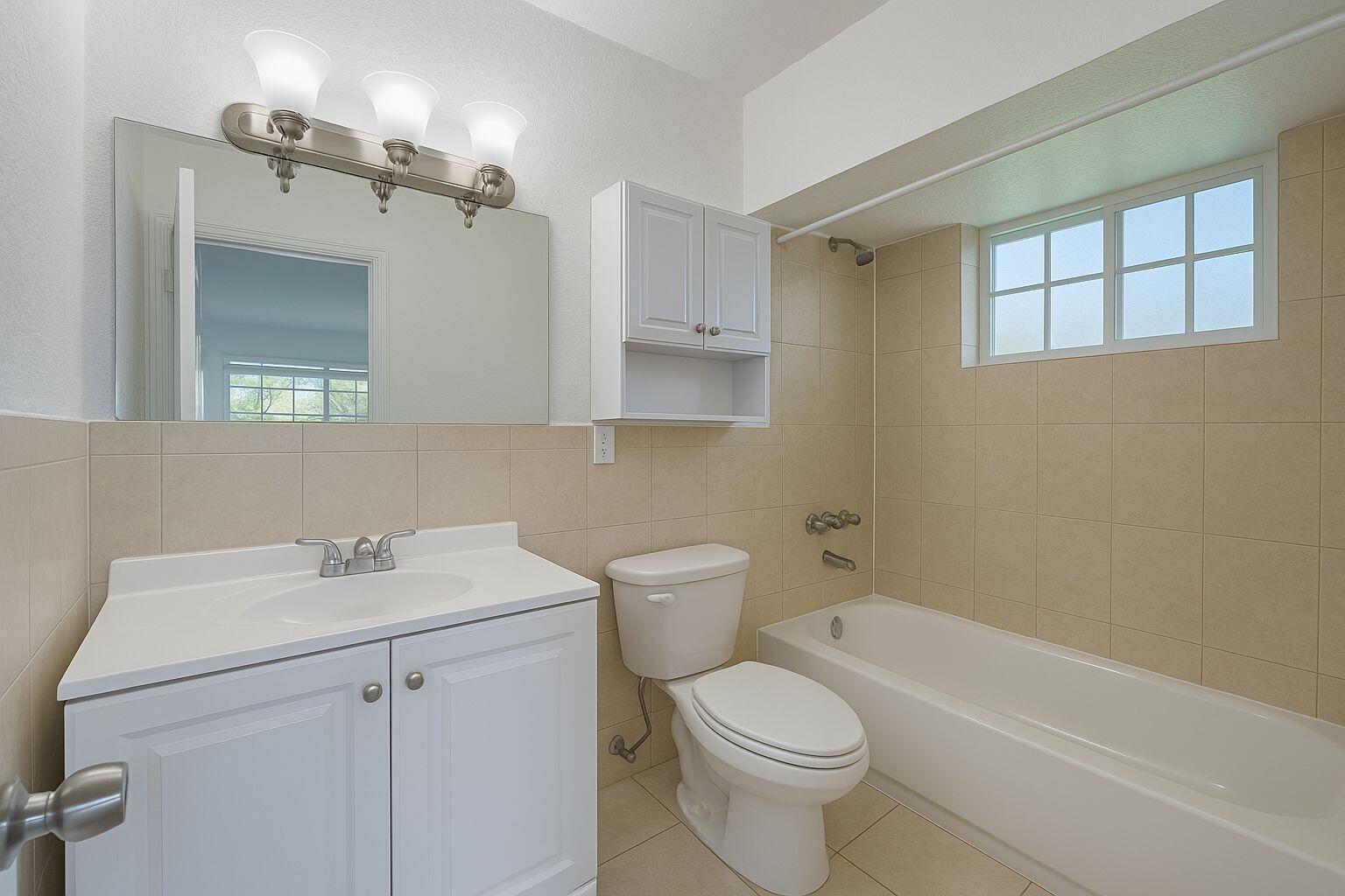 A bathroom features a white vanity, a toilet, and a tiled bathtub shower combination — 3390 NE 16th Terrace # 5, Pompano Beach FL 33064, POMPANO BEACH, FL