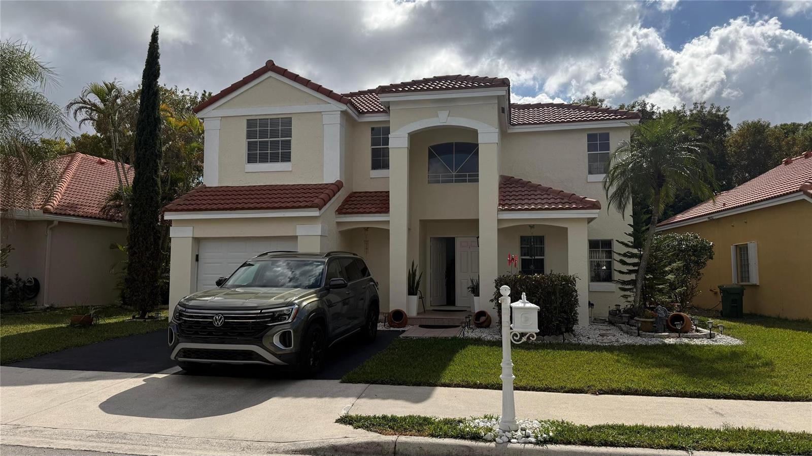A two-story stucco house with a tile roof and a car parked in the driveway — 593 Bedford Avenue, Weston FL 33326, WESTON, FL